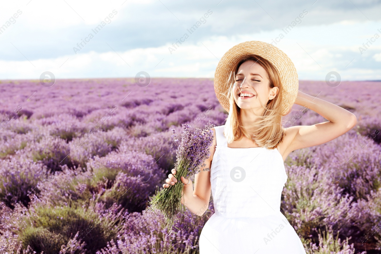 Photo of Young woman with bouquet in lavender field