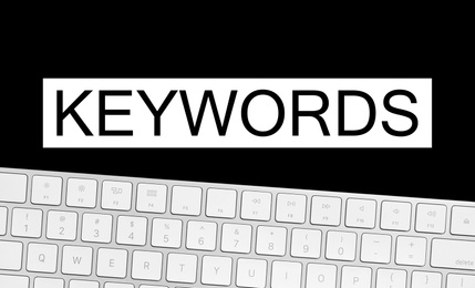 Word Keywords and computer keyboard on black background. SEO direction