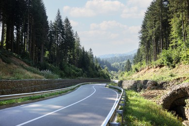 Photo of Picturesque view of empty asphalt road near forest