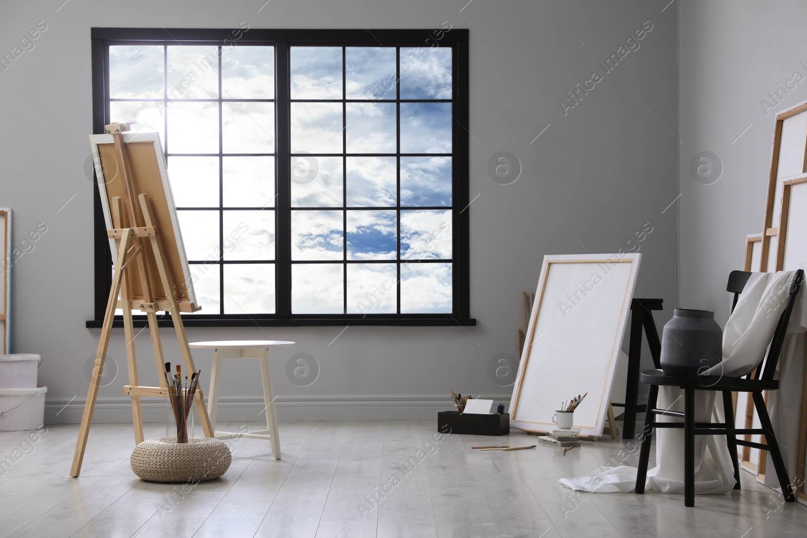 Photo of Stylish artist's studio interior with easel and brushes