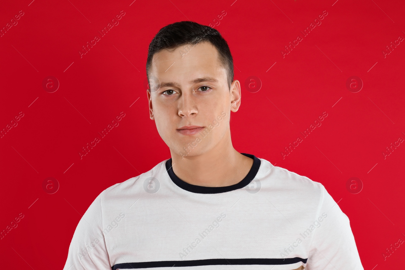 Photo of Handsome young man posing on red background