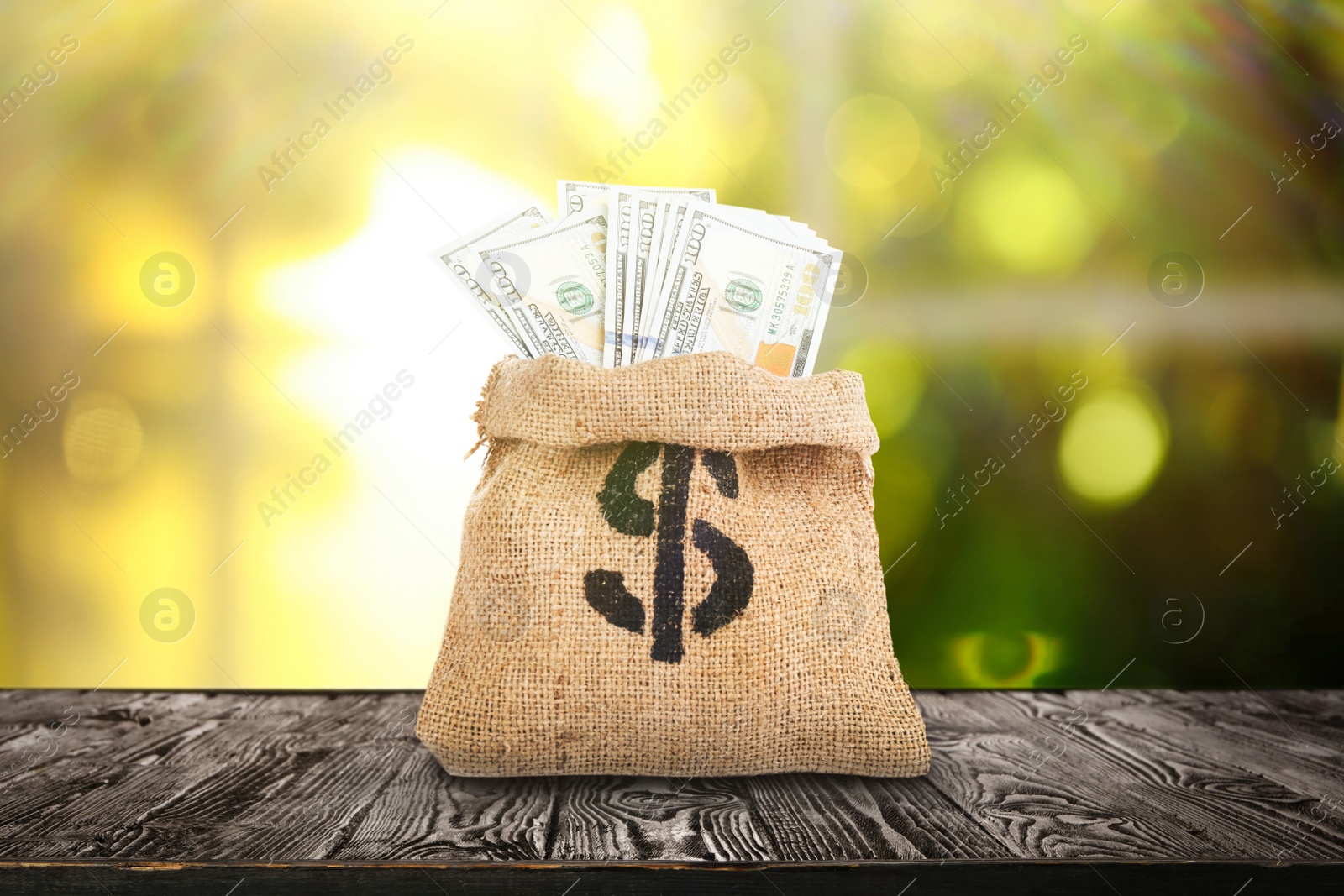 Image of Burlap bag with dollar sign and banknotes on wooden table indoors