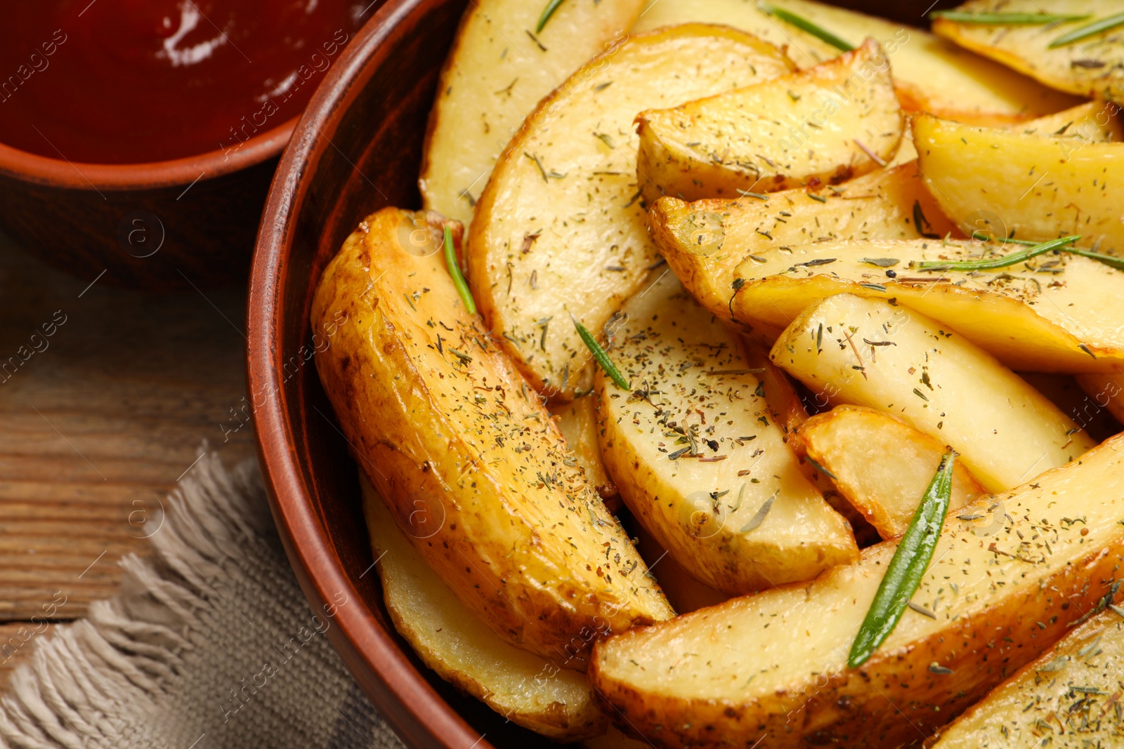 Photo of Delicious baked potatoes with spices on wooden table, closeup