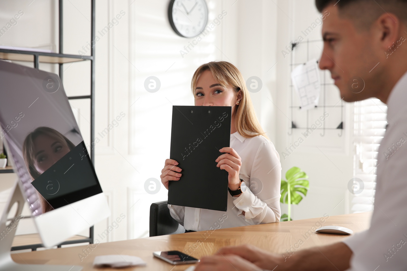 Photo of Young woman flirting with her colleague during work in office