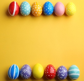 Flat lay composition of painted Easter eggs on color background, space for text