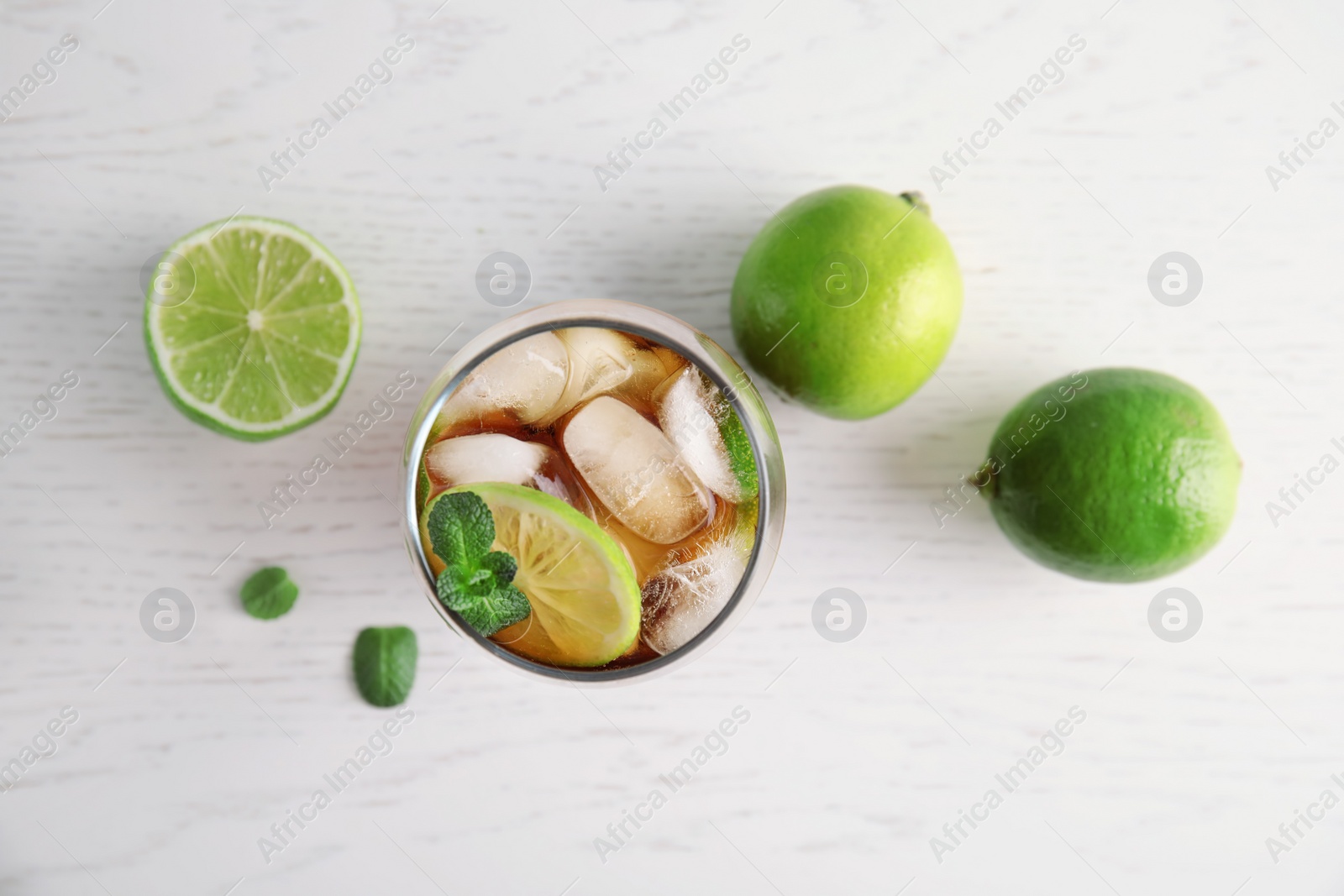 Photo of Flat lay composition with glass of coke and ice cubes on wooden background