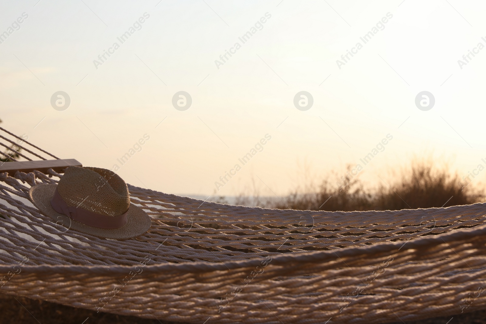 Photo of Hammock with hat hanging outdoors. Time to relax