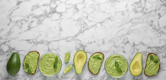 Photo of Flat lay composition with guacamole, sandwiches and avocados on white marble table. Space for text