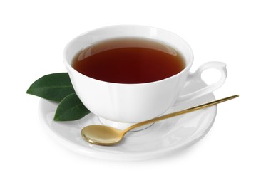 Aromatic tea in cup, golden spoon and green leaves isolated on white