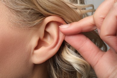 Photo of Closeup view of woman touching her ear