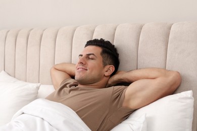 Happy man lying in bed at home