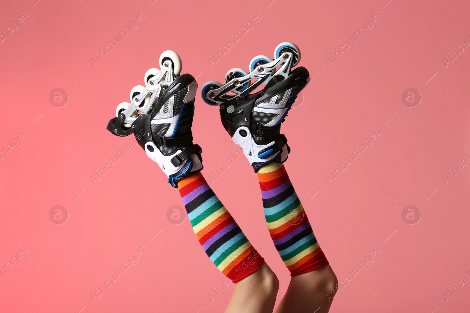 Photo of Woman with roller skates on color background, closeup