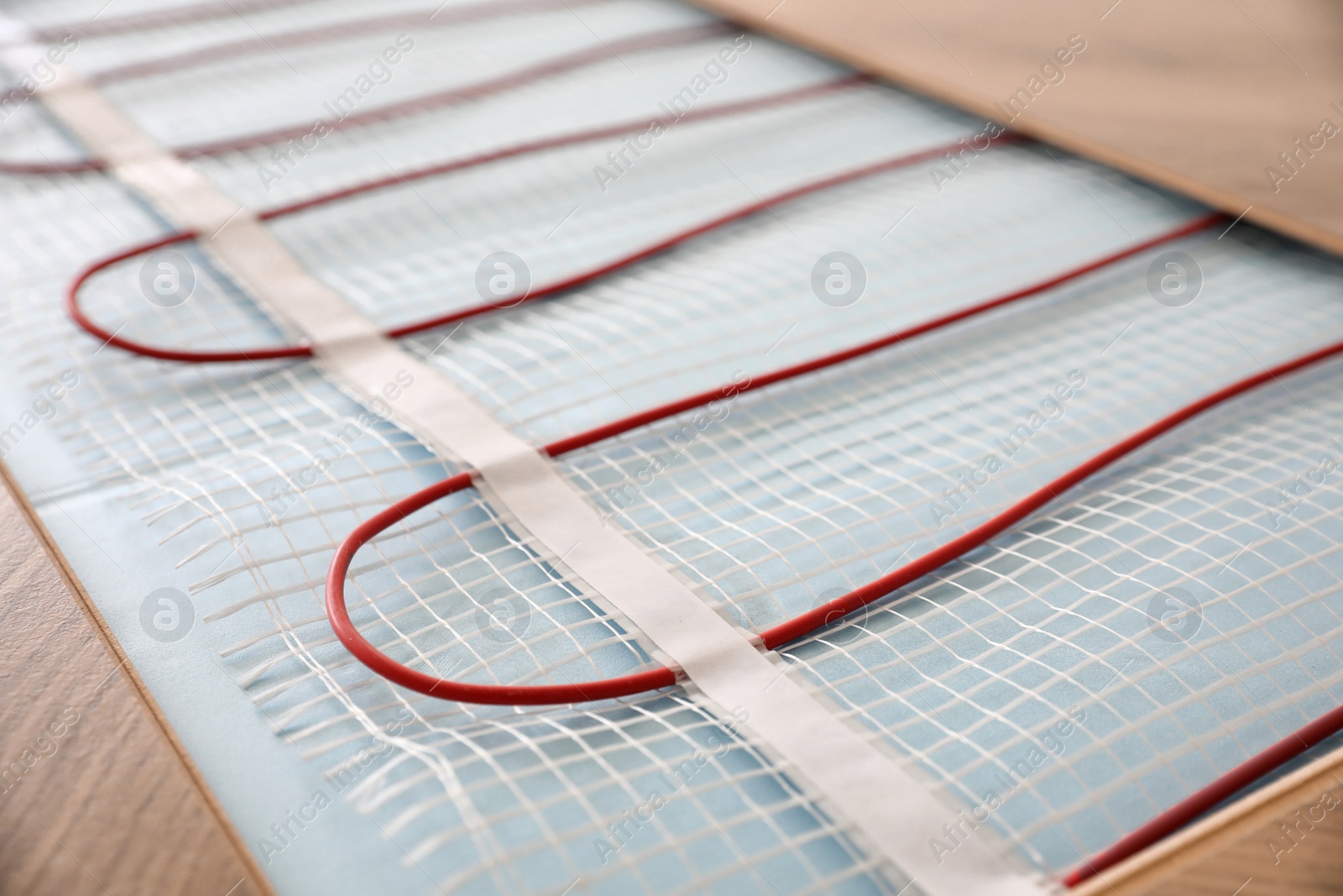 Photo of Installation of modern underfloor trace heating system indoors, closeup