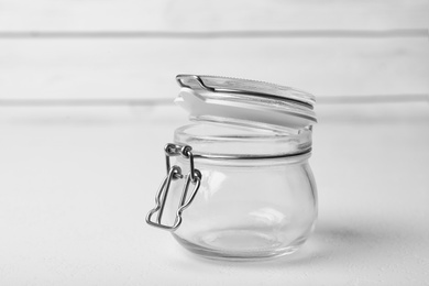 Photo of Open empty glass jar on white table