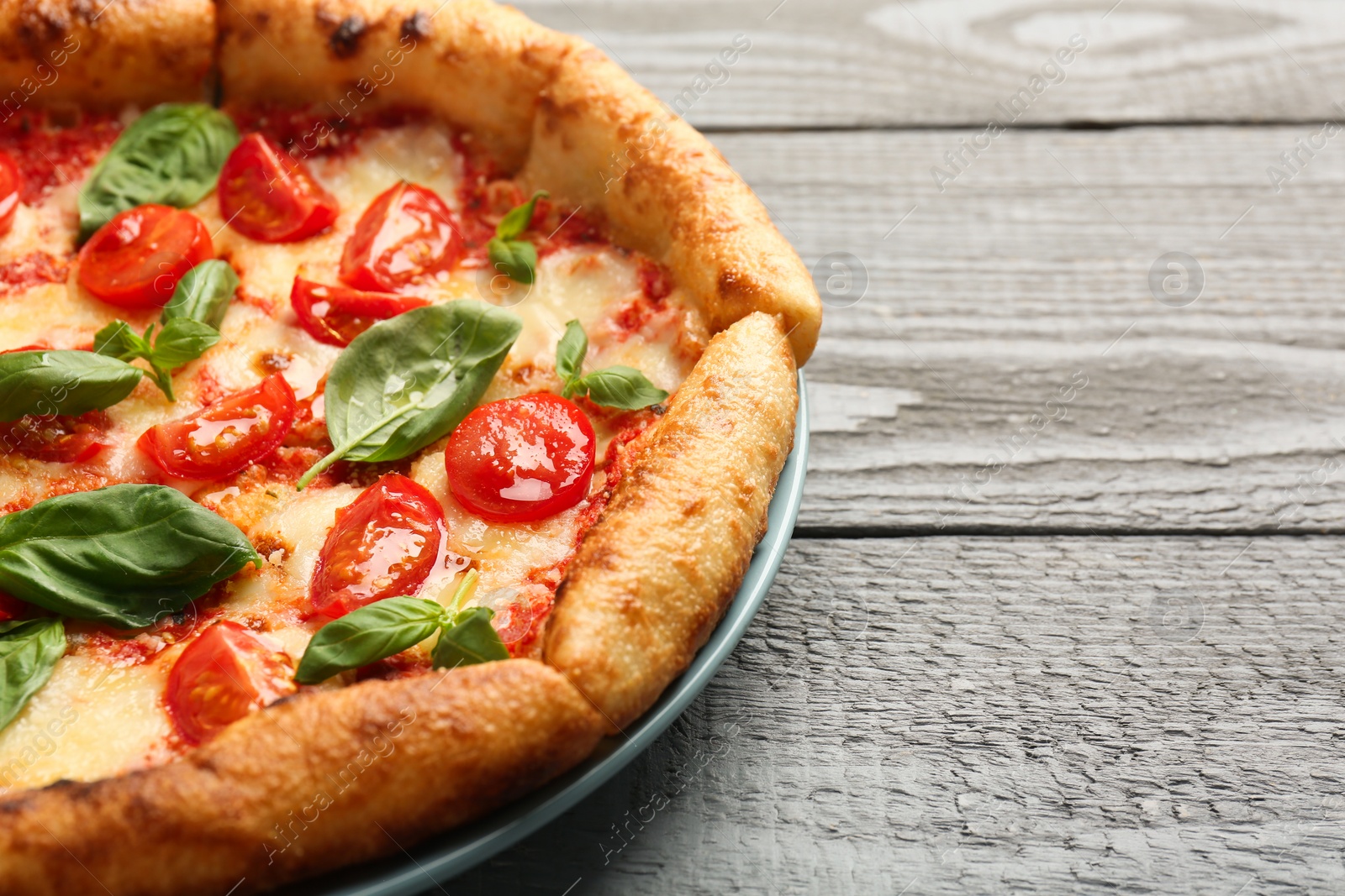 Photo of Delicious Margherita pizza on gray table, closeup. Space for text