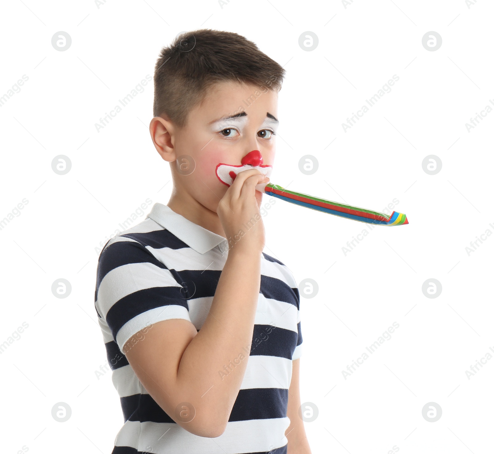 Photo of Preteen boy with clown makeup and party horn on white background. April fool's day
