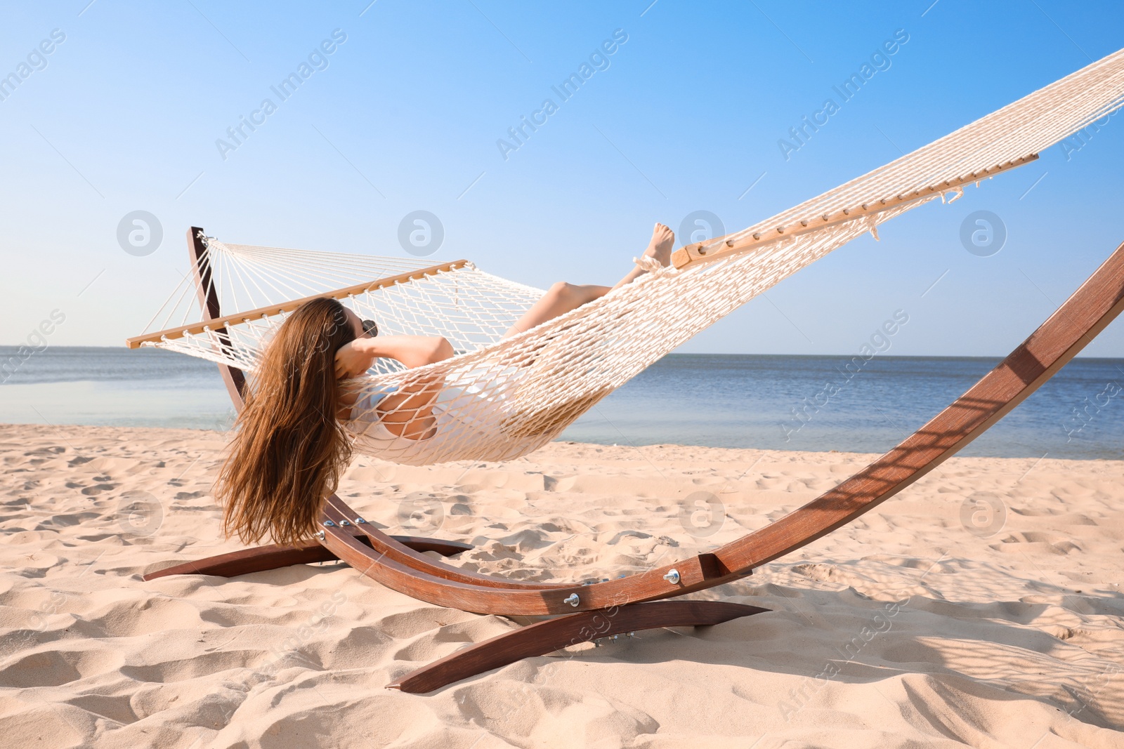 Photo of Young woman relaxing in hammock on beach