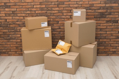 Photo of Stacked parcel boxes on floor against brick wall