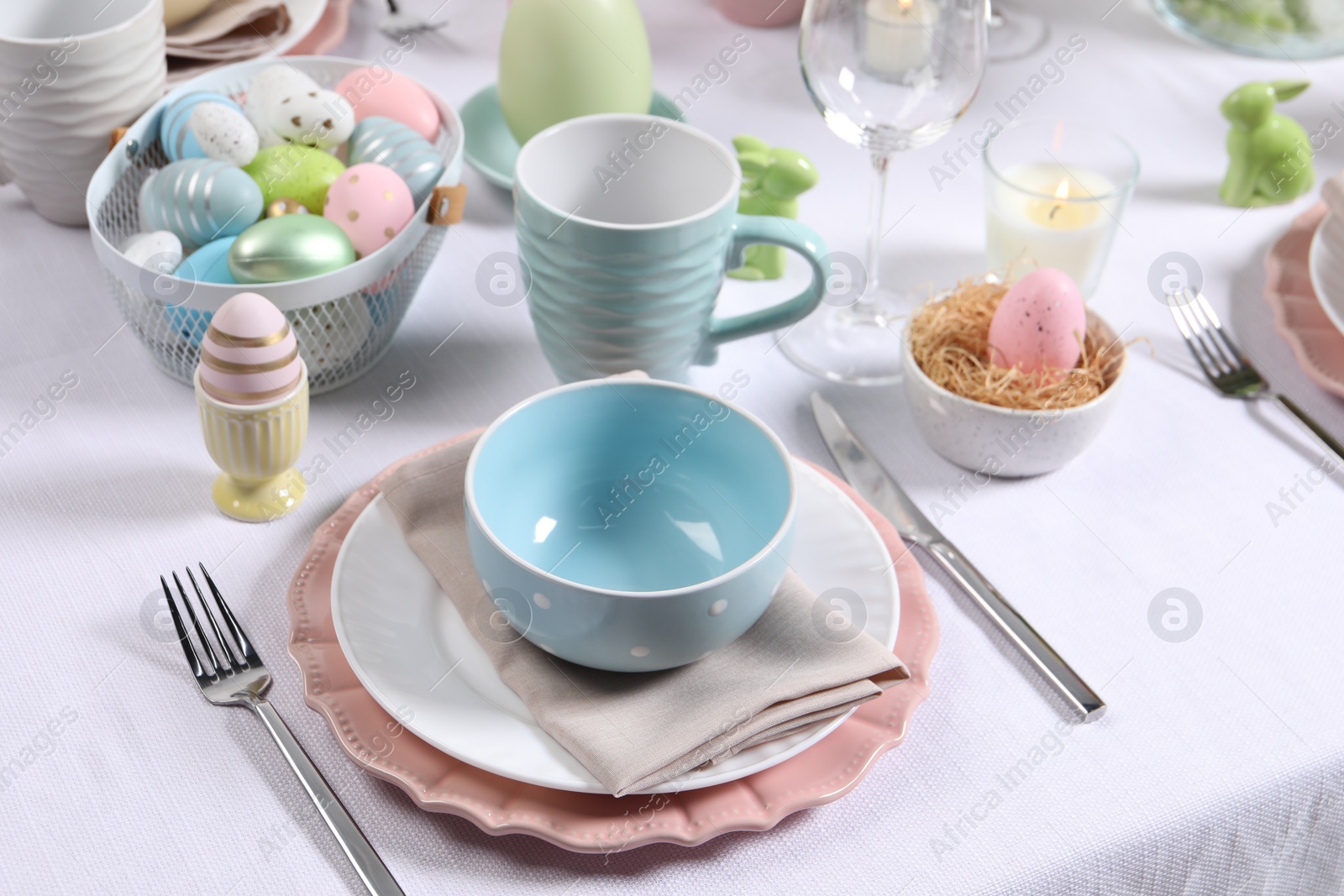 Photo of Festive table setting with painted eggs. Easter celebration