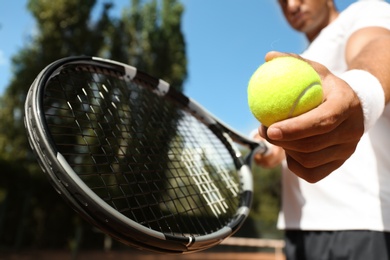 Photo of Sportsman preparing to serve tennis ball at court, closeup