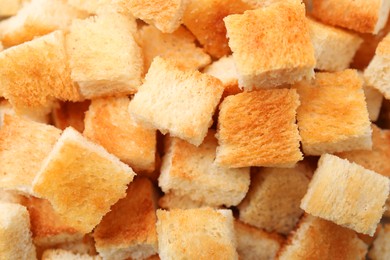 Photo of Delicious crispy croutons as background, closeup view