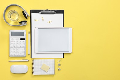 Photo of Flat lay composition with modern tablet on yellow background. Space for text