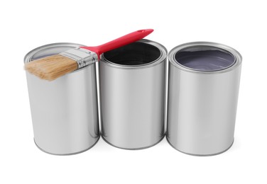 Cans with different paints and brush on white background