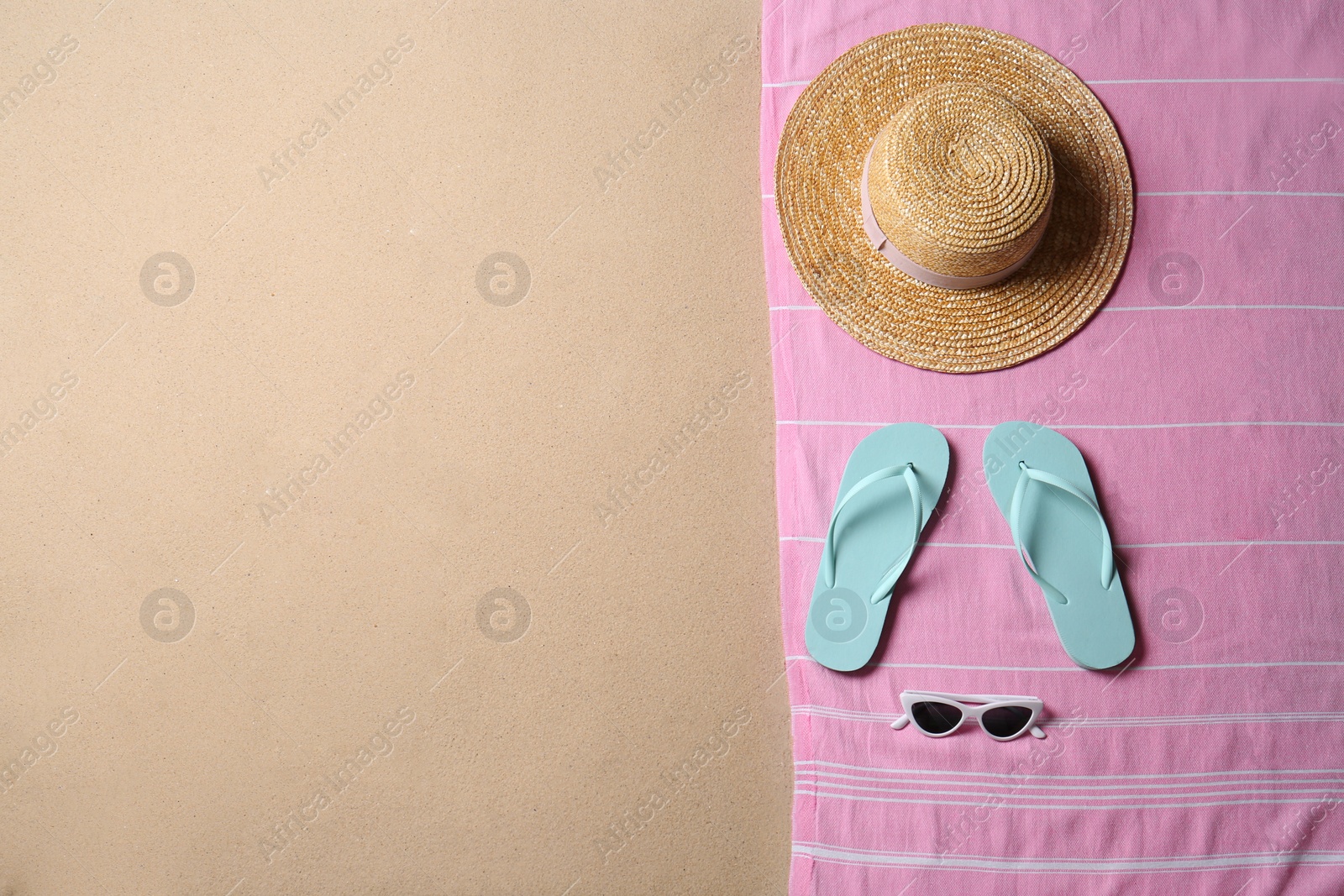 Photo of Beach accessories and space for text on sand, top view. Summer vacation