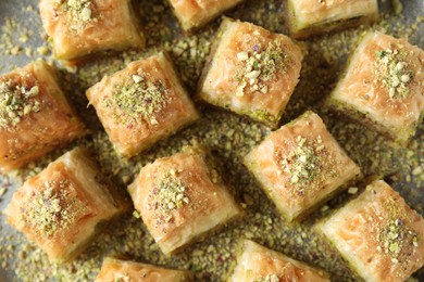 Photo of Delicious fresh baklava with chopped nuts on table, flat lay. Eastern sweets