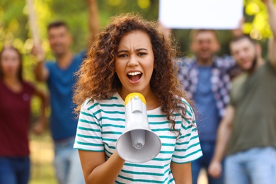 Photo of Angry African-American woman with megaphone at protest outdoors