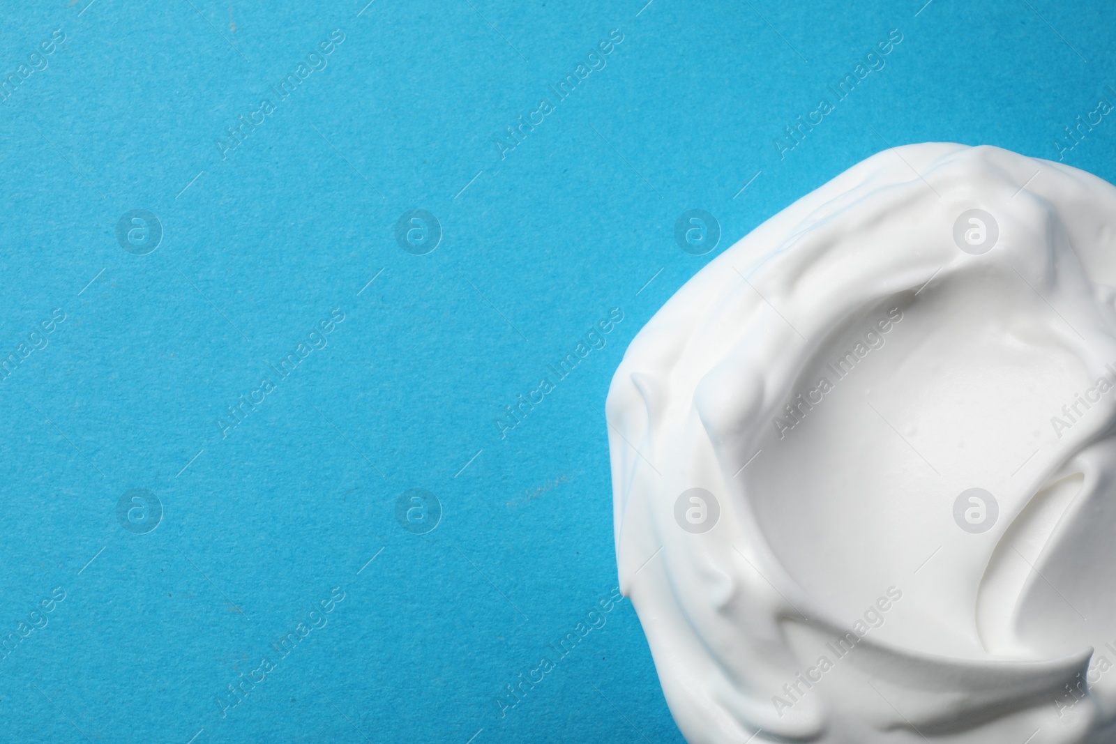 Photo of Sample of shaving foam on blue background, top view. Space for text