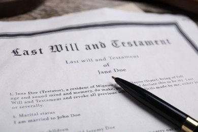 Photo of Last will and testament with pen on table, closeup