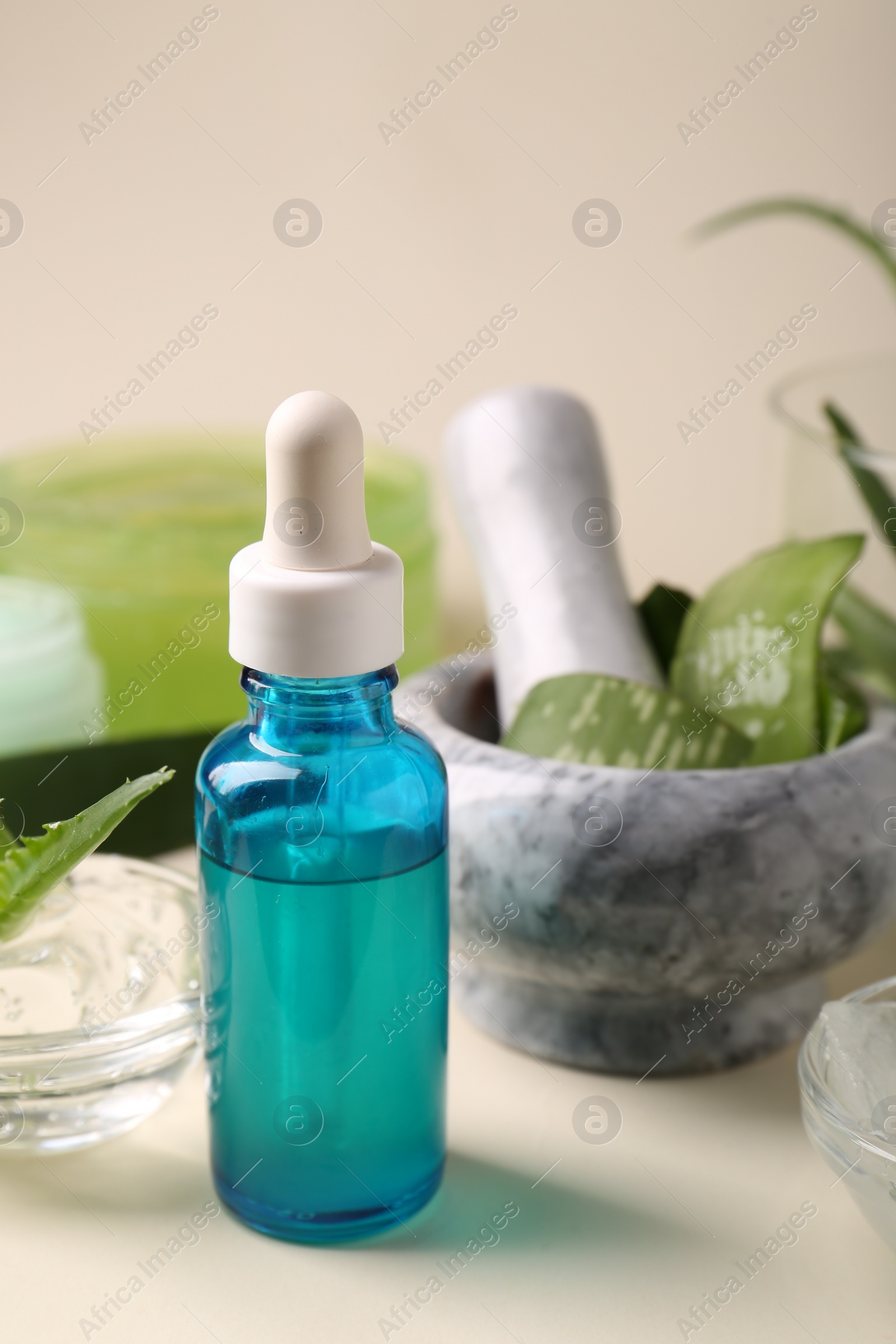 Photo of Bottle of cosmetic product with aloe extract on beige background, closeup