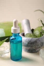 Bottle of cosmetic product with aloe extract on beige background, closeup