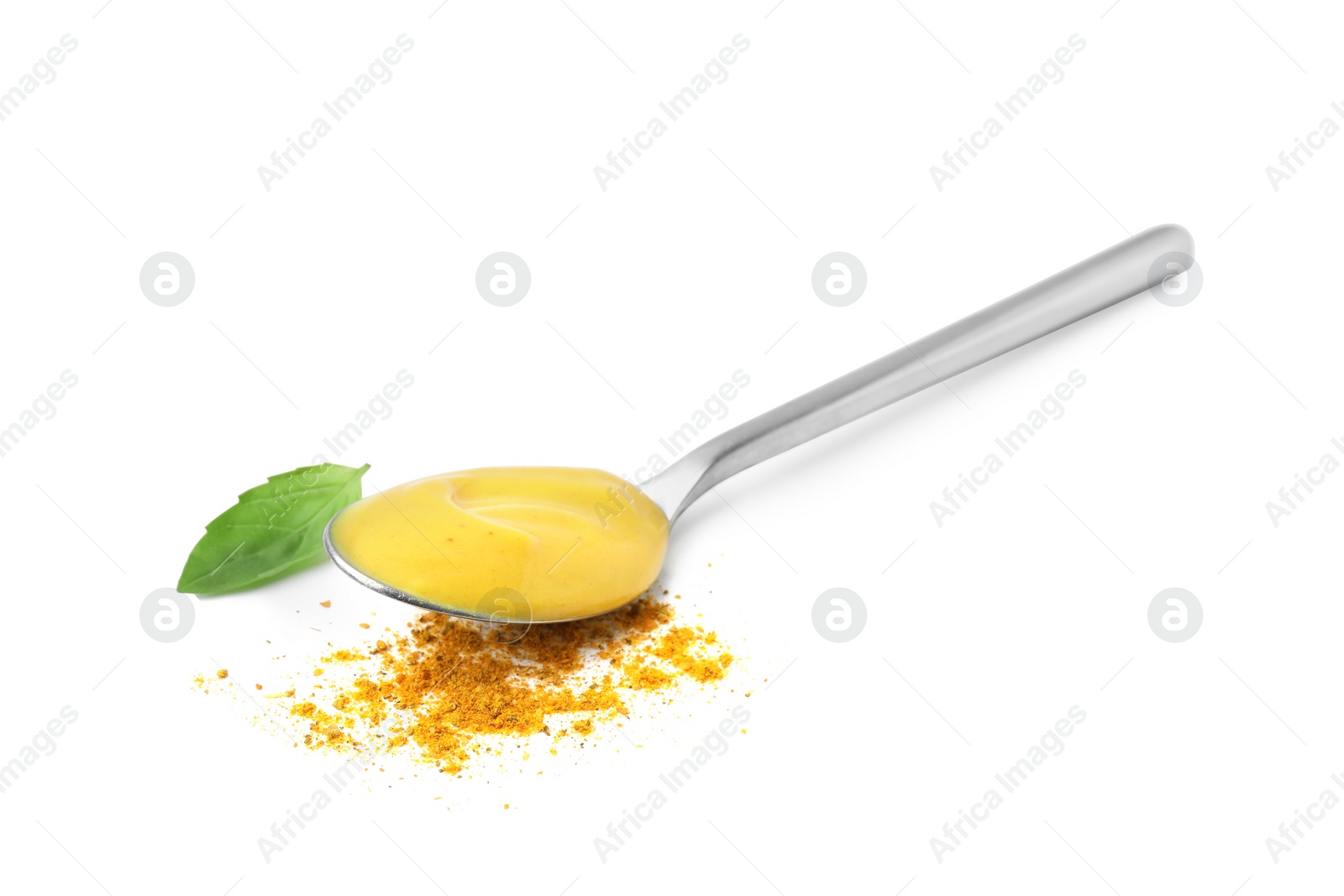 Photo of Spoon with tasty curry sauce, powder and basil leaf isolated on white