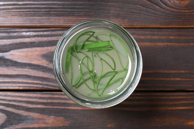 Photo of Fresh aloe juice in jar on wooden table, top view