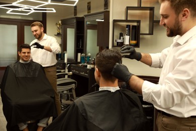 Photo of Professional hairdresser making stylish haircut in salon