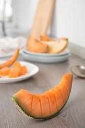 Photo of Slice of ripe cantaloupe melon on wooden table