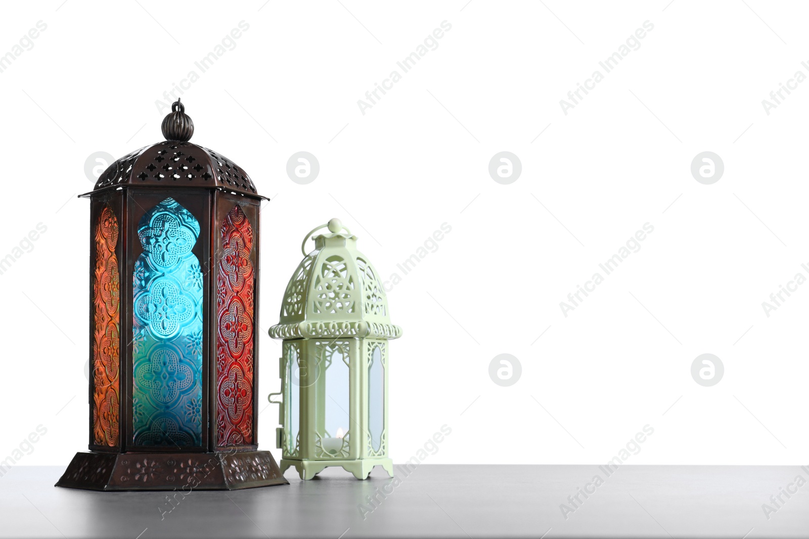 Photo of Decorative Arabic lanterns on grey table against white background