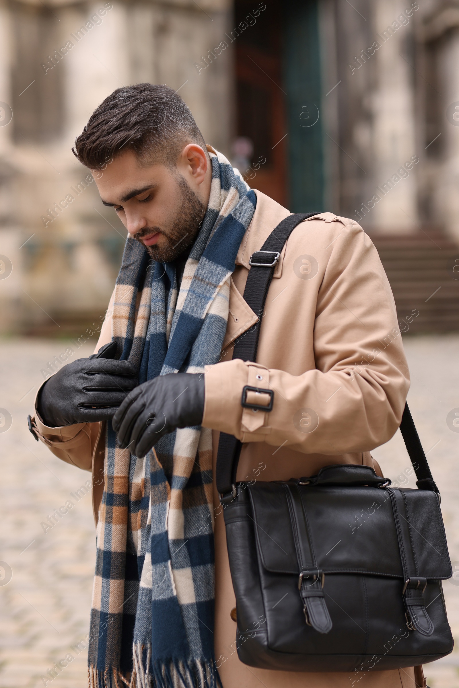 Photo of Handsome man in warm scarf on city street