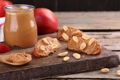 Photo of Fresh apples with peanut butter on wooden table