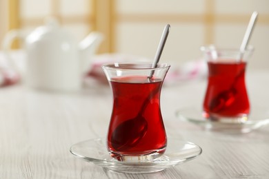 Photo of Glasses of traditional Turkish tea on white wooden table indoors