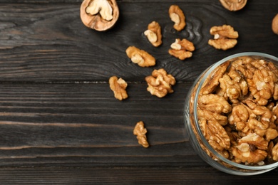 Photo of Flat lay composition with walnuts and space for text on wooden background