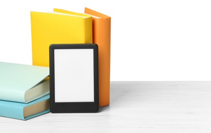Photo of Hardcover books and modern e-book on wooden table against white background. Space for text