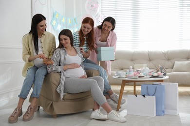 Happy pregnant woman spending time with friends at baby shower party