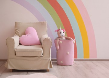 Photo of Cute child's room interior with beautiful rainbow painted on wall