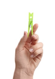 Woman holding bright green plastic clothespin on white background, closeup