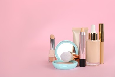 Foundation makeup products on pink background, space for text. Decorative cosmetics