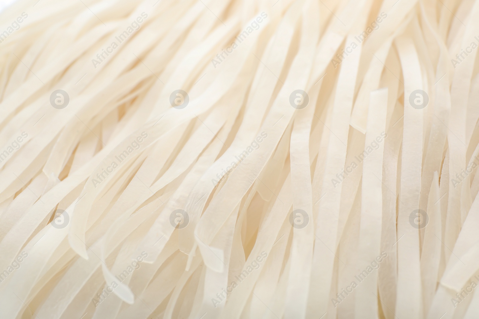 Photo of Raw rice noodles as background, closeup. Delicious pasta