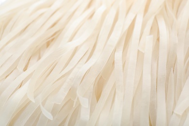 Photo of Raw rice noodles as background, closeup. Delicious pasta